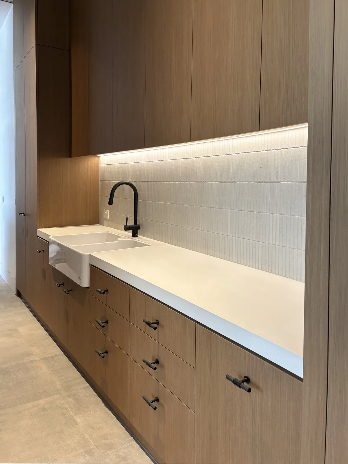 Bone white concrete kitchen island and coffee station in an SG2 Architects-designed Elsternwick home, paired with light timber joinery