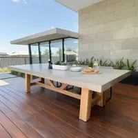 Farmhouse concrete dining table on an outdoor timber deck with succulents and bread setting