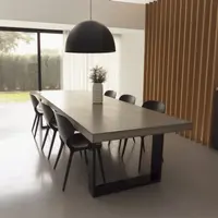 IronStone concrete dining table in a high-ceiling dining room with oak slatted partition and black pendant