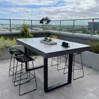 IronStone concrete bar table on a rooftop terrace with black wire stools and Melbourne view