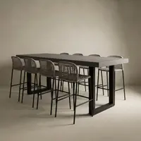 Studio render of the IronStone concrete bar table in dark grey with black steel sled legs and woven barstools