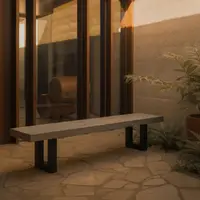 IronStone concrete bench seat on a flagstone courtyard at golden hour, fern beside an architectural timber-framed window