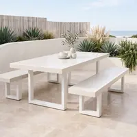 White IronStone concrete dining table and bench seat on a coastal terrace with agaves, pampas grass and ocean view