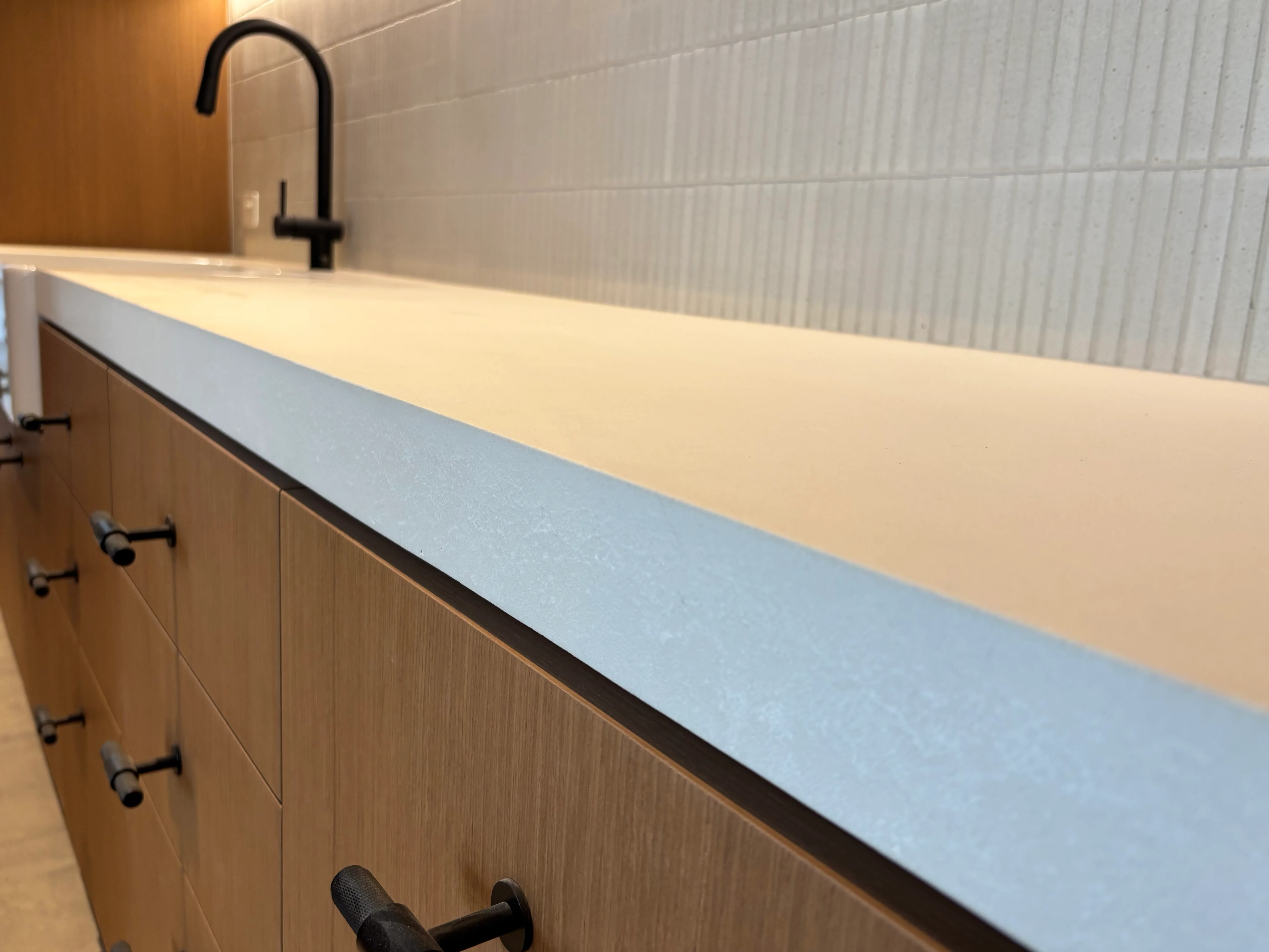 Polished concrete benchtop with built-up apron edge by SnapCo, hand-cast in Mordialloc for kitchens and joinery