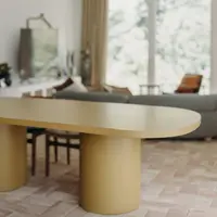 Yellow ochre Palermo oval concrete dining table close-up over warm parquet floor