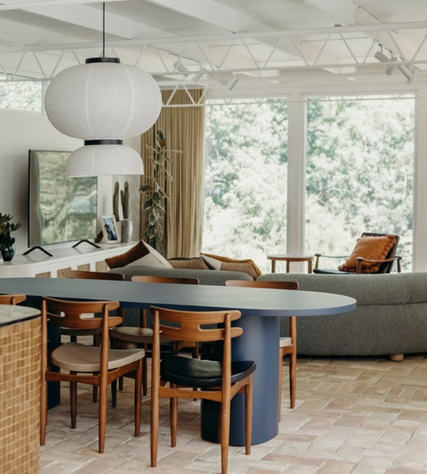 Navy Palermo oval concrete dining table with timber chairs and paper lanterns in a sunlit living space
