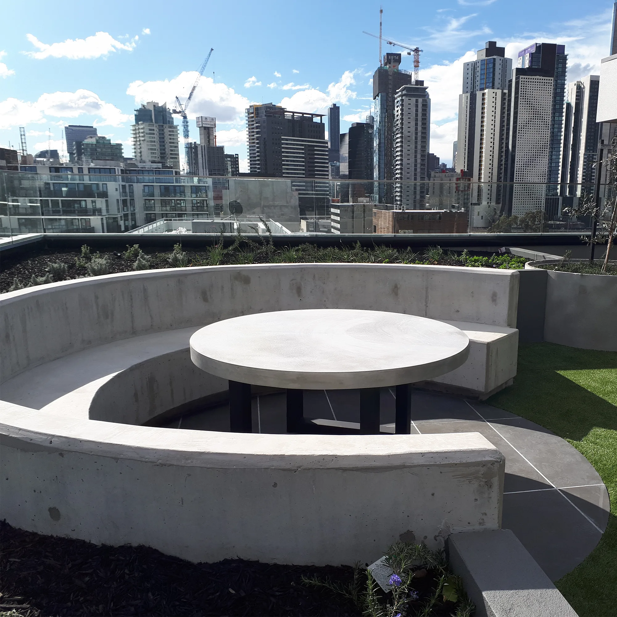 Curved concrete banquette and round cafe tables hand-cast by SnapCo for The Beverly Rooftop hospitality fit-out in South Yarra