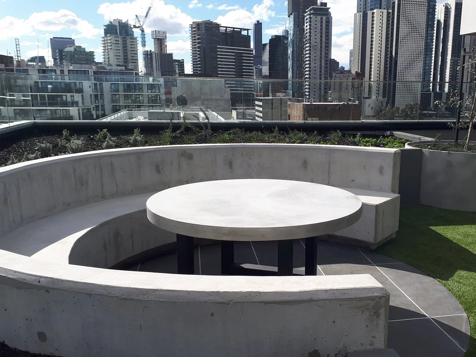 Curved concrete banquette and round cafe tables hand-cast by SnapCo for The Beverly Rooftop hospitality fit-out in South Yarra