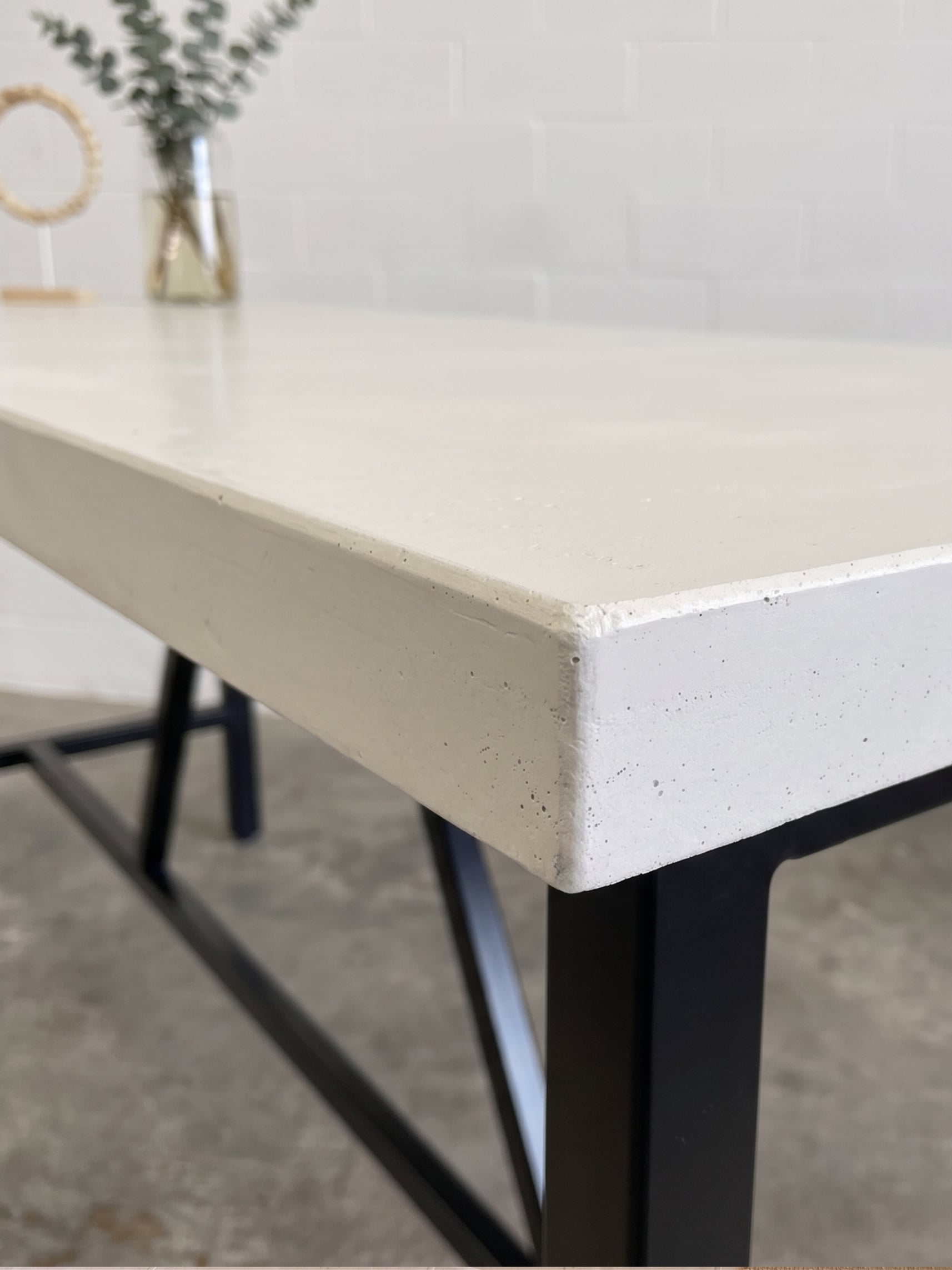 SnapCo Santino concrete bar table with bone-white top and steel base, photographed in situ