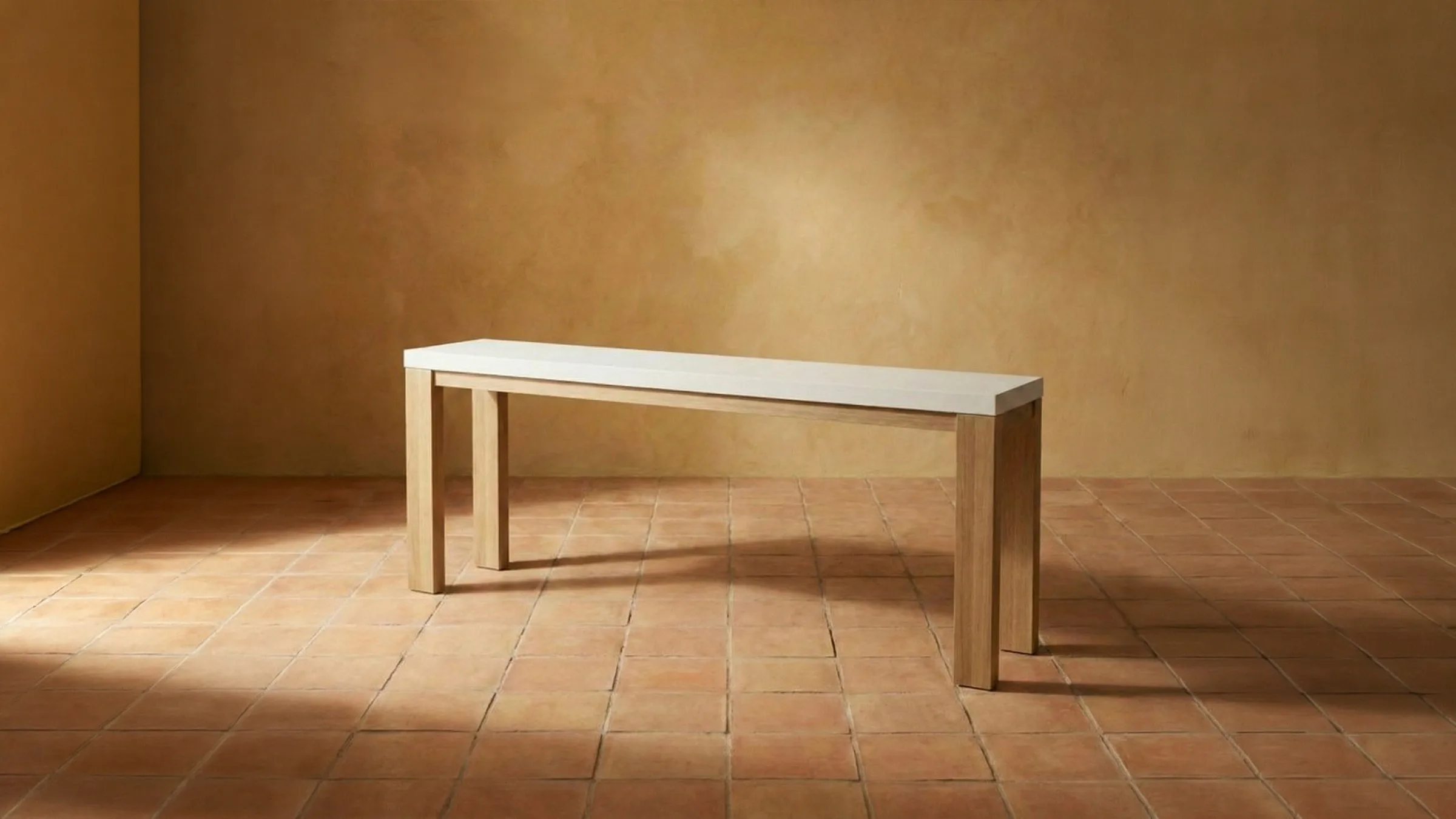A SnapCo Laconian white-top concrete hall table on terracotta tile, warm ochre wall behind