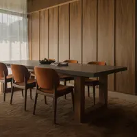 TimberStone concrete dining table in a warm timber-panelled dining room with orange velvet chairs