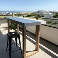 TimberStone concrete bar table on a Gold Coast balcony with ocean and beach view behind