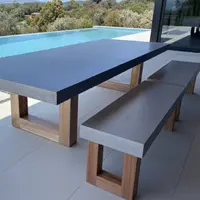 TimberStone concrete dining table and bench seat on a poolside terrace overlooking an infinity pool and bushland