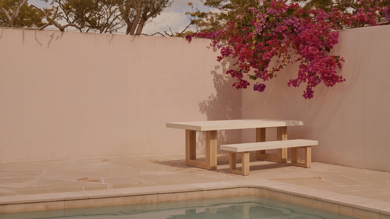 TimberStone concrete bench seat in Bone White on a sandstone pool terrace with bougainvillea overhead and pink plaster wall