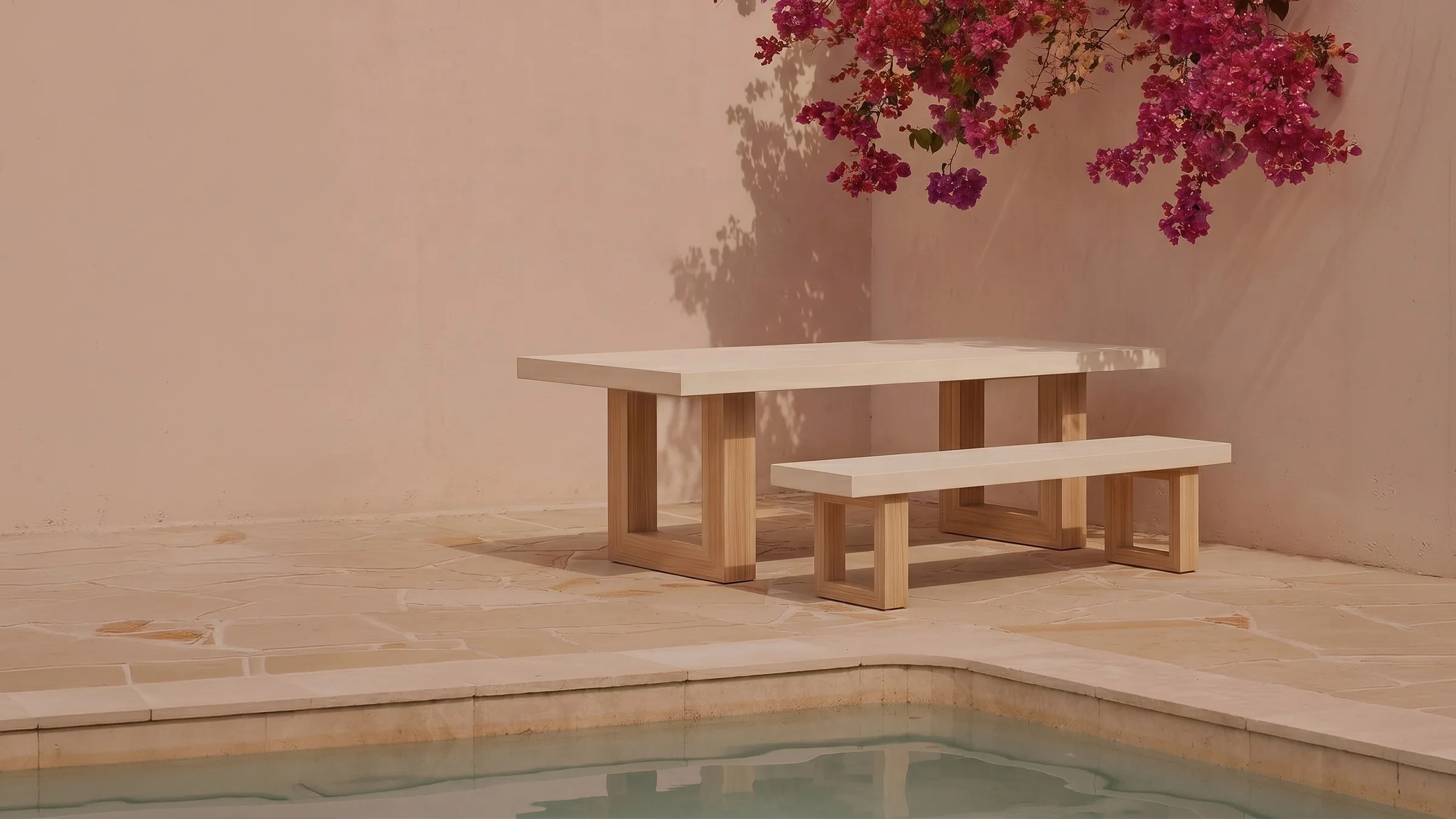 A SnapCo TimberStone bone-white concrete dining table and bench beside a Mediterranean pool, bougainvillea overhead